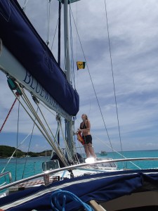 A student of Grenada Bluewater Sailing raises the SVG courtesy flag.
