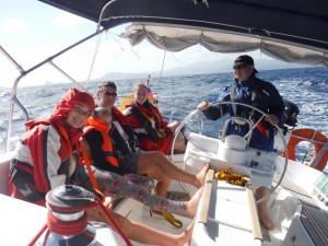 A family learning to sail wearing their lifejackets.