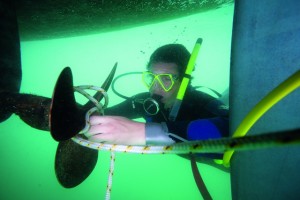 A scuba diver untangling a fouled prop.