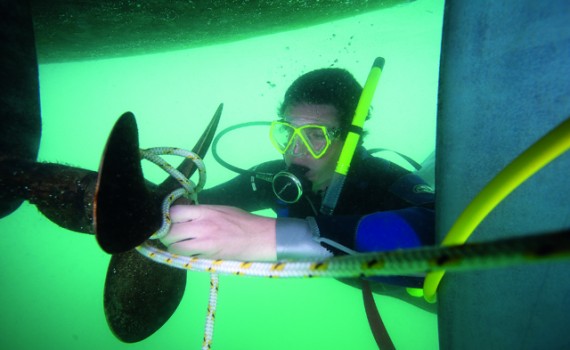 A scuba diver untangling a fouled prop.